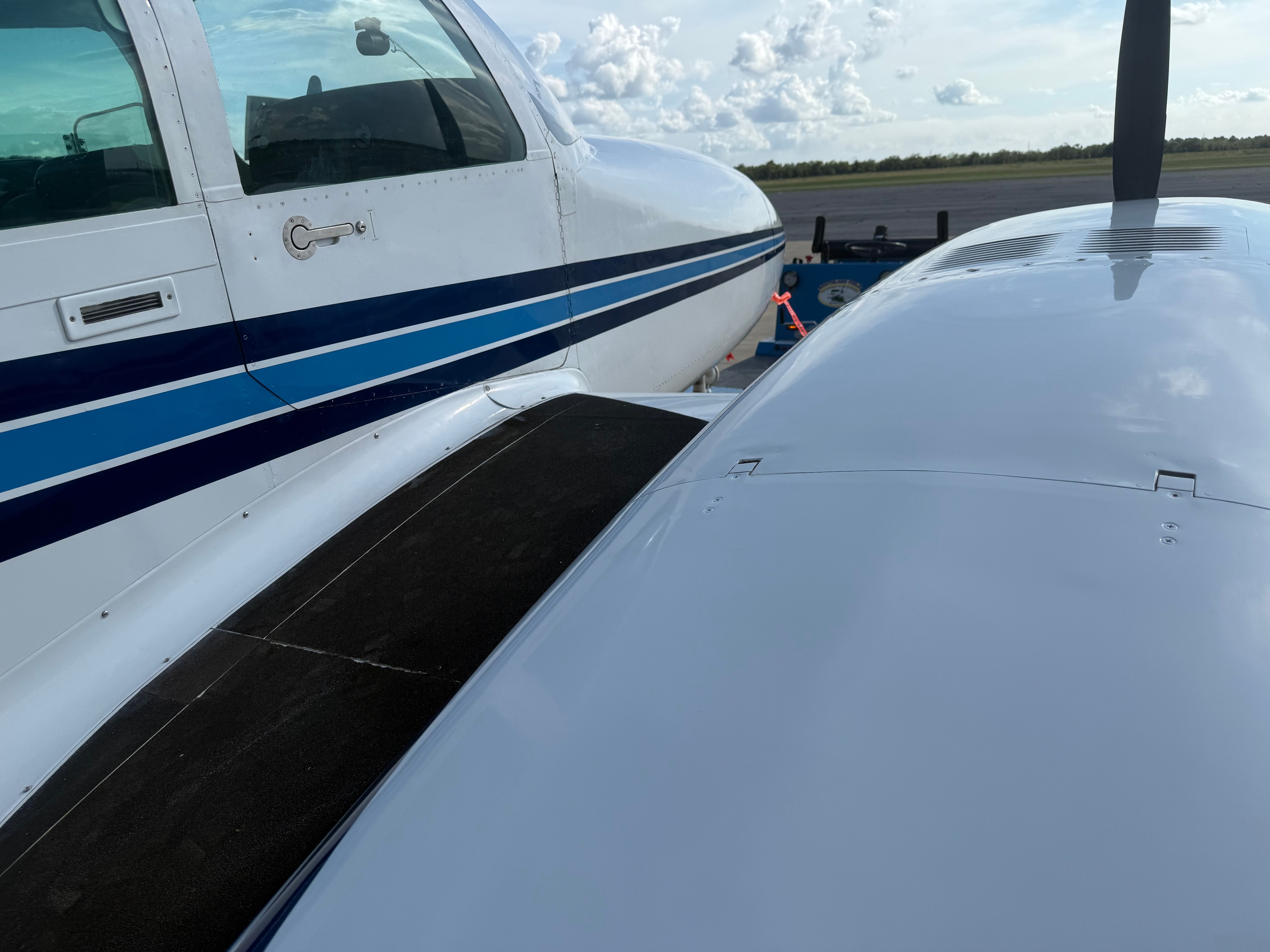 Close-up of Cessna 310R wing surface and fuselage detail on tarmac